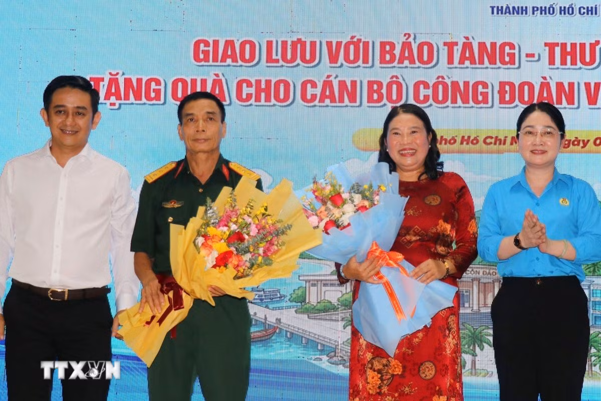 Đại diện Thành ủy Thành phố Hồ Chí Minh và Liên đoàn Lao động Thành phố Hồ Chí Minh tặng hoa các đại biểu tham gia tọa đàm, giao lưu tại tọa đàm, giao lưu. (Ảnh: Thanh Vũ/TTXVN)